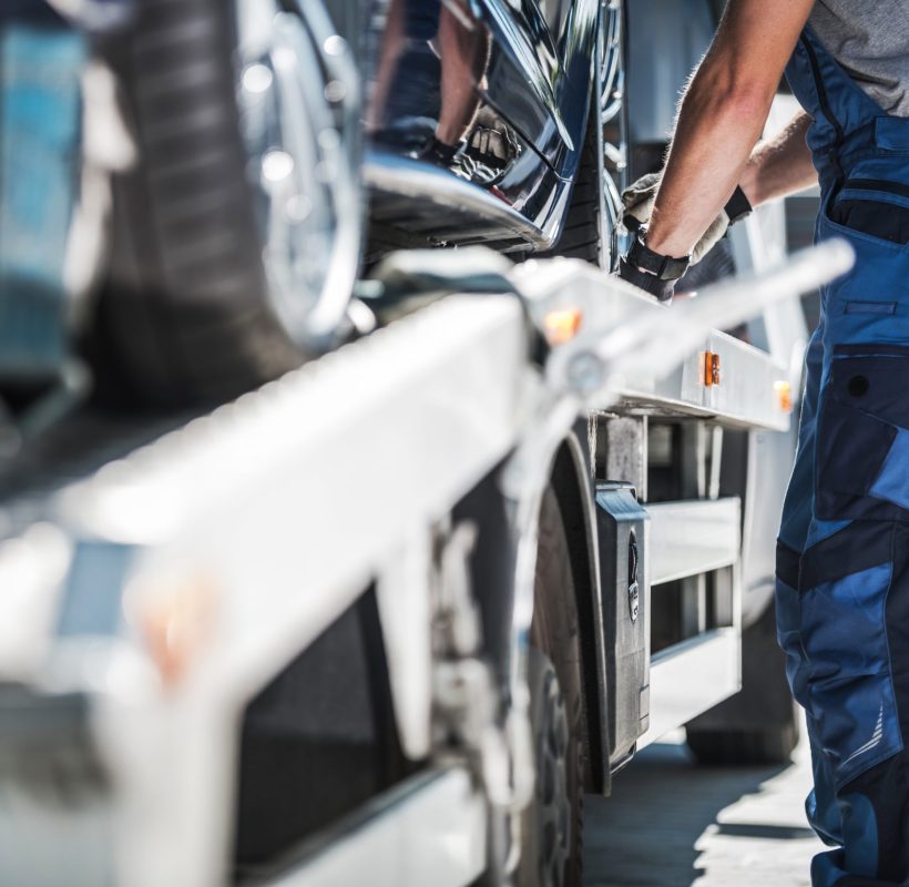 Professional Repo Worker Securing Car on a Towing Truck.